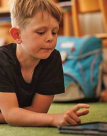 Kind am Tablett im Unterricht der Montessori Schule Starnberg