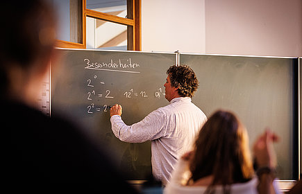 Lehrer an der Tafel in der Montessori Schule Starnberg